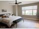 Spacious bedroom with natural light, wood floors, ceiling fan, and decorative bench at 984 W Belmont Red Trl, San Tan Valley, AZ 85143