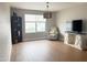 Cozy bedroom with chair and entertainment center, featuring wood floors and natural light at 984 W Belmont Red Trl, San Tan Valley, AZ 85143