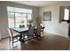 Dining area with pool view from the window, featuring a dark wood table and neutral chairs at 984 W Belmont Red Trl, San Tan Valley, AZ 85143