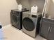 Modern laundry room with front loading washer and dryer, utility sink and grey cabinets at 984 W Belmont Red Trl, San Tan Valley, AZ 85143