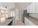 Kitchen area with white cabinets, stainless steel appliances, island sink, and a view of the living room at 10280 N 94Th Dr, Peoria, AZ 85345