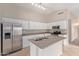 Bright kitchen featuring an island with sink, white cabinets, and stainless steel appliances at 10280 N 94Th Dr, Peoria, AZ 85345