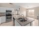 Kitchen view featuring stainless steel appliances, a kitchen island with a sink, and views to the living room at 10280 N 94Th Dr, Peoria, AZ 85345