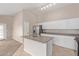 Bright kitchen with white cabinets, stainless appliances, and an island that seamlessly transitions to the living area at 10280 N 94Th Dr, Peoria, AZ 85345