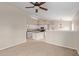 Open floor plan showcases the living room flowing seamlessly into the kitchen with an island and white cabinets at 10280 N 94Th Dr, Peoria, AZ 85345