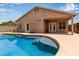 Inviting backyard pool surrounded by a spacious patio, covered porch, and home exterior at 10280 N 94Th Dr, Peoria, AZ 85345