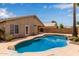 Backyard featuring a blue swimming pool, rock features, and green foliage at 10280 N 94Th Dr, Peoria, AZ 85345