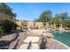 Lush backyard oasis featuring a pool, spa, rock waterfall, and cozy seating area with a fireplace at 10434 N 44Th N St, Phoenix, AZ 85028