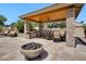 Outdoor kitchen features stone accents, a built-in grill, and a cozy fire pit for outdoor enjoyment at 10434 N 44Th N St, Phoenix, AZ 85028