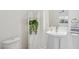 The charming powder room is complete with pedestal sink, decor and cabinet for storage at 11872 W Duane Ln, Peoria, AZ 85383
