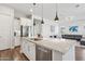 Large kitchen island with stainless steel appliances, sink, and view of the living area at 11872 W Duane Ln, Peoria, AZ 85383