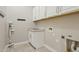 This laundry room includes storage cabinets, hanging hooks and a laundry sink at 11872 W Duane Ln, Peoria, AZ 85383