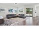 Spacious living room with a large sectional sofa, modern decor, and ample natural light from surrounding windows at 11872 W Duane Ln, Peoria, AZ 85383