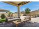 Comfortable covered patio with stone pavers, furnished with outdoor seating and a coffee table for relaxing and enjoying the backyard at 11872 W Duane Ln, Peoria, AZ 85383