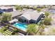 Stunning aerial view of a backyard featuring a pool, landscaped green space, lounge chairs, and outdoor kitchen area at 12035 S 186Th Ave, Goodyear, AZ 85338
