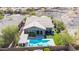 Aerial view of backyard with sparkling pool, covered patio, and lush landscaping, perfect for outdoor entertaining at 12035 S 186Th Ave, Goodyear, AZ 85338
