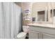 Bright bathroom featuring tiled shower with blue striped curtain and marble counter at 12035 S 186Th Ave, Goodyear, AZ 85338