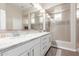 Elegant bathroom featuring double sinks with marble counters and a glass-enclosed tiled shower at 12035 S 186Th Ave, Goodyear, AZ 85338