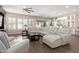 Bright living room with a large white sectional sofa, wood-look tile flooring, and ample natural light at 12035 S 186Th Ave, Goodyear, AZ 85338