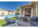 Inviting outdoor patio with comfortable seating, a fire pit, and a view of the sparkling pool, perfect for relaxing and entertaining at 12035 S 186Th Ave, Goodyear, AZ 85338