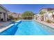 Beautiful blue pool with a built-in spa and desert landscaping, enhancing the backyard's tranquil and refreshing atmosphere at 12035 S 186Th Ave, Goodyear, AZ 85338