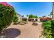A fully landscaped backyard showcases flowering bushes, rock formations, a grill, and privacy fencing at 14124 W Bent Tree S Cir, Litchfield Park, AZ 85340