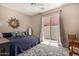 Bedroom featuring a queen bed, decorative mirror, and sliding glass doors to a patio at 14124 W Bent Tree S Cir, Litchfield Park, AZ 85340