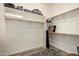 Bright walk-in closet with shelving, wooden rods, and carpet at 14124 W Bent Tree S Cir, Litchfield Park, AZ 85340