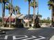 Community entrance provides controlled access in a neighborhood with mature palm trees, landscaping, and an American flag at 14124 W Bent Tree S Cir, Litchfield Park, AZ 85340