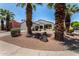 Charming single-story home boasts mature palm trees, desert landscaping, and a welcoming covered front porch at 14124 W Bent Tree S Cir, Litchfield Park, AZ 85340