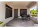 Covered front porch offers a shady place to sit with a table and chairs and enjoy views of the landscaped front yard at 14124 W Bent Tree S Cir, Litchfield Park, AZ 85340
