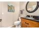 Charming powder room with decorative painting, mirror, and wood vanity at 14124 W Bent Tree S Cir, Litchfield Park, AZ 85340
