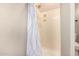 Shower featuring a neutral-toned shower curtain and a built-in shelving unit at 14124 W Bent Tree S Cir, Litchfield Park, AZ 85340