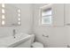 Bright, all-white bathroom with a modern vanity, lighted mirror, and window at 143 E Winter Dr, Phoenix, AZ 85020