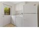 Bright laundry room features a washer, dryer, utility cabinets, and access to the outside at 143 E Winter Dr, Phoenix, AZ 85020