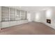 Spacious living room with built-in shelving, a brick fireplace, and neutral carpeting at 143 E Winter Dr, Phoenix, AZ 85020
