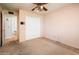 Bright bedroom with ensuite bathroom, ceiling fan, and closet with bi-fold doors at 1562 W Las Palmaritas Dr, Phoenix, AZ 85021