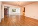 Open-concept living room with hardwood floors, decorative chandelier, and kitchen views at 1562 W Las Palmaritas Dr, Phoenix, AZ 85021