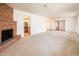 Spacious carpeted living room boasts a brick fireplace, access to other rooms and plenty of light at 1562 W Las Palmaritas Dr, Phoenix, AZ 85021