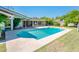 Inviting backyard pool with a spacious patio and lush lawn, complemented by a sunroom with many windows at 1562 W Las Palmaritas Dr, Phoenix, AZ 85021