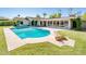 Inviting backyard pool with a spacious patio and lush lawn, complemented by a sunroom with many windows at 1562 W Las Palmaritas Dr, Phoenix, AZ 85021