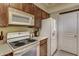Bright kitchen with classic white appliances, wood cabinets, and tiled floors at 16525 E Avenue Of The Fountain -- # 113, Fountain Hills, AZ 85268