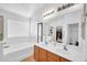 Bright bathroom featuring double sinks, separate shower, and large soaking tub at 16887 W Belleview St, Goodyear, AZ 85338
