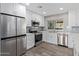 Modern kitchen features new stainless appliances, white cabinetry, and gray tile backsplash at 1701 E Camino Del Santo --, Phoenix, AZ 85022