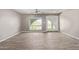 Bright living room boasts a ceiling fan, outside views, and wood-look tile flooring at 1701 E Camino Del Santo --, Phoenix, AZ 85022