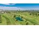 An aerial view shows a scenic golf course with a lake and the city skyline in the distance at 1814 W Thomas Rd, Phoenix, AZ 85015