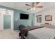 Comfortable bedroom featuring a ceiling fan, TV, and a stylish chaise lounge for relaxation at 1814 W Thomas Rd, Phoenix, AZ 85015