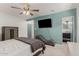 Spacious bedroom with ceiling fan, TV, and a modern chaise lounge at 1814 W Thomas Rd, Phoenix, AZ 85015