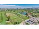 Aerial view showcasing the driving range, lake, parking area, and the city skyline in the background at 1814 W Thomas Rd, Phoenix, AZ 85015