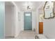 Bright entryway with a modern light fixture, light wood flooring, and a decorative mirror at 1814 W Thomas Rd, Phoenix, AZ 85015